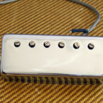 A Guitar Pickup sitting loose on a Tweed Amplifier
